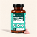 An amber glass bottle of Intimate Rose Digestive Enzymes dietary supplement with a teal and white label, shown on a light beige background with two pink capsules resting beside the bottle.