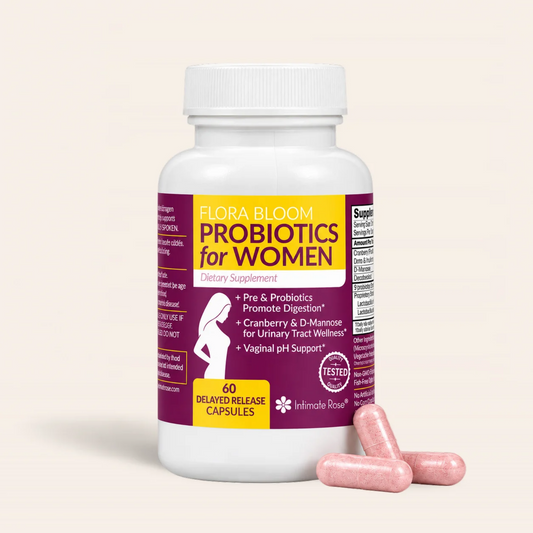 A white plastic bottle of Flora Bloom Probiotics for Women dietary supplement with a purple and yellow label, shown with three pink capsules in front on a light beige background.