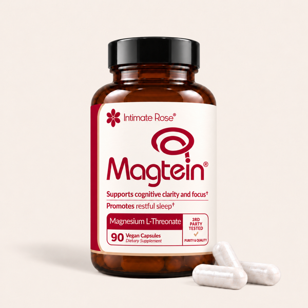 An amber glass bottle of Intimate Rose Magtein dietary supplement with a black cap and white label, shown on a light beige background with three white capsules in front.