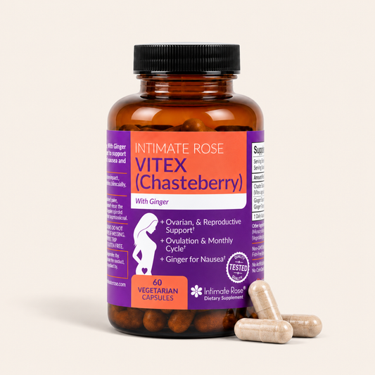 An amber glass bottle of Intimate Rose Vitex (Chasteberry) dietary supplements with a black cap, purple and orange label, and three beige capsules in the foreground, set against a solid off-white background.