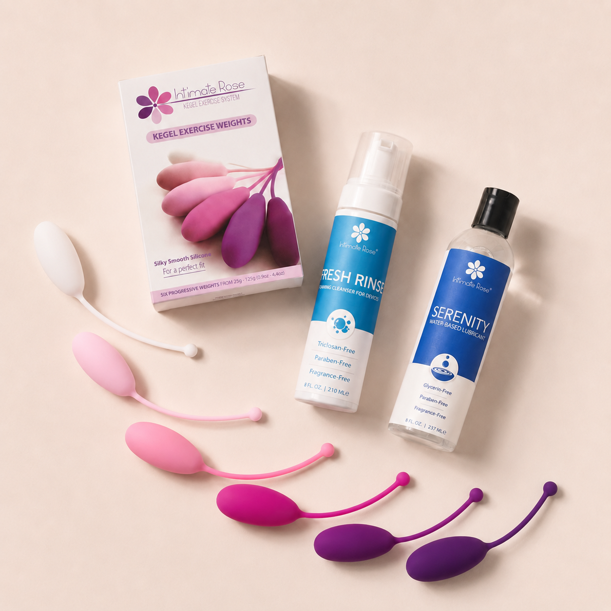 Flat lay of the Intimate Rose Pelvic Floor Strength Bundle with six Kegel weights, Fresh Rinse cleanser, and Serenity lubricant